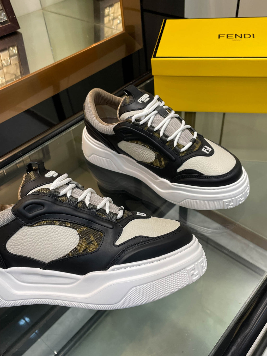Pair of dark and white unisex sneakers with lace-up uppers and padded collars