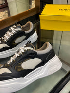 Close-up of dark and white unisex sneakers, lace-up with logo patch details