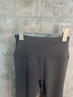 Black athletic leggings with wide waistband and stitched panel