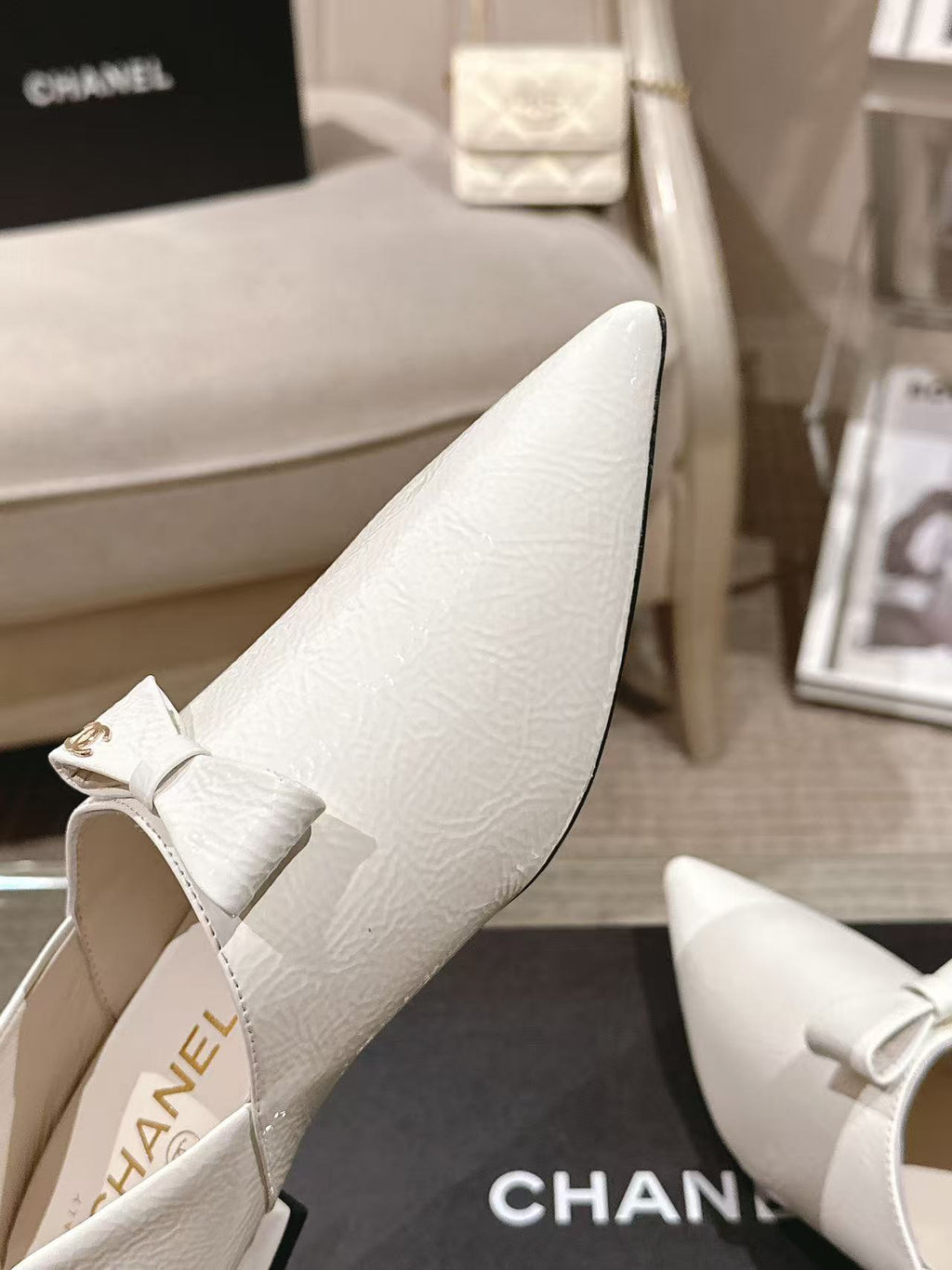 White leather pointed-toe flats with bow strap, side close-up