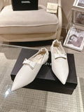 White leather pointed-toe flats with bow strap detail