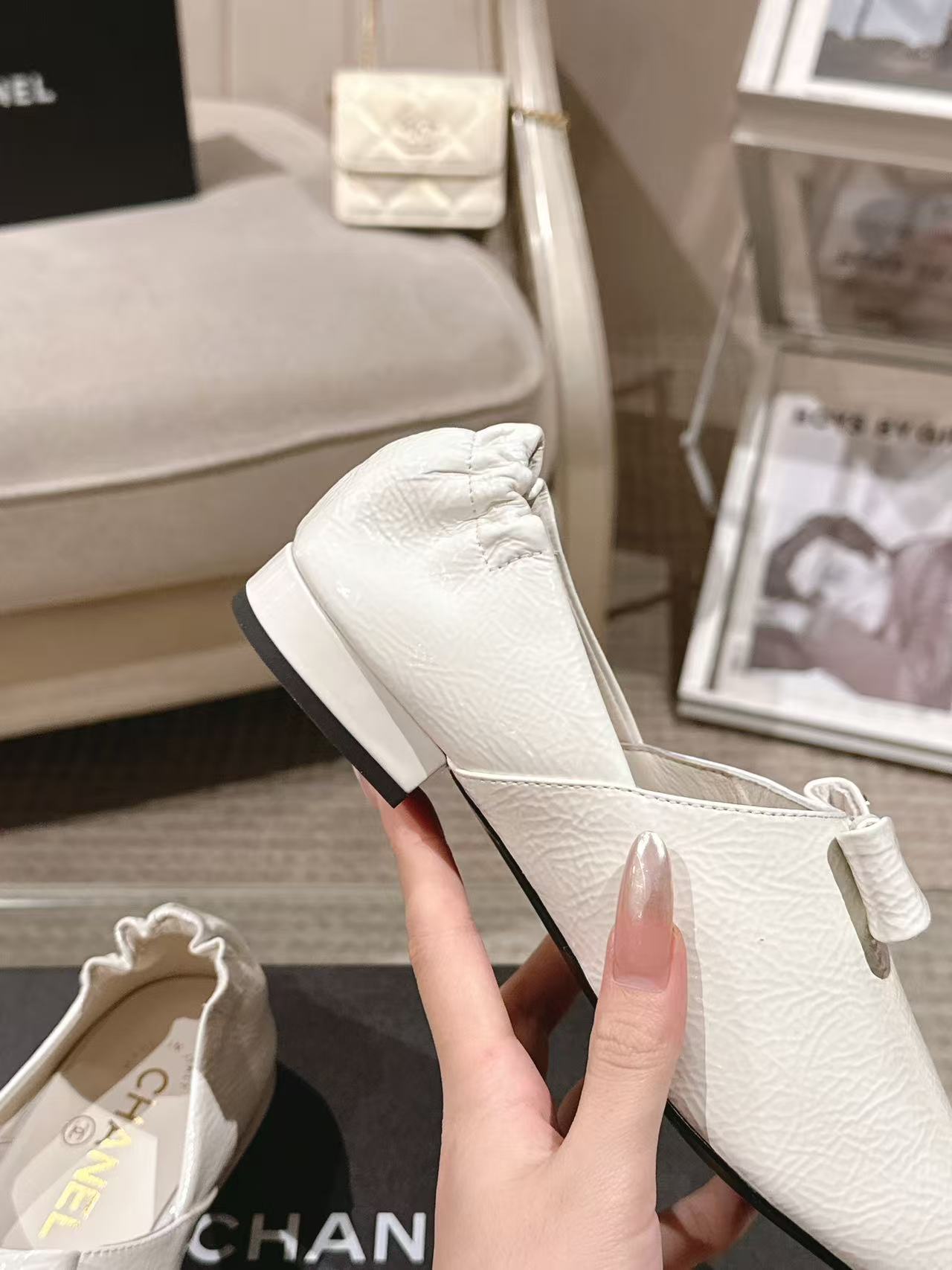 White leather pointed-toe flat with bow strap, angled side view