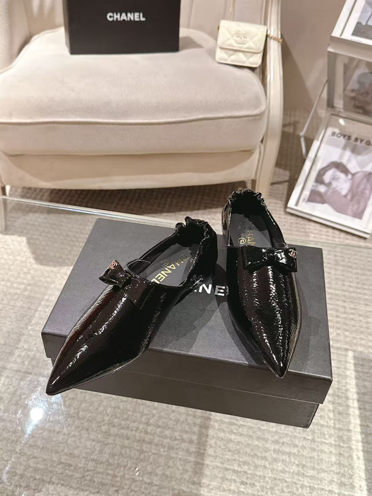 Pair of black patent leather ladies pointed-toe slip-on shoes with bow and low block heel