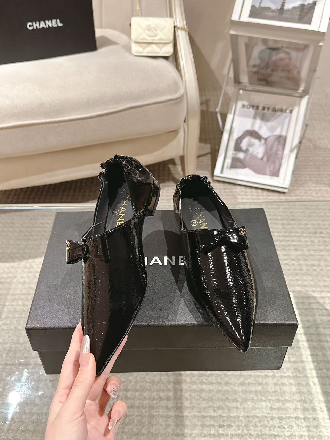 Black patent leather ladies pointed-toe slip-on shoes with bow detail and low heel