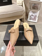 Beige patent mule slides with bow strap, pair on display box