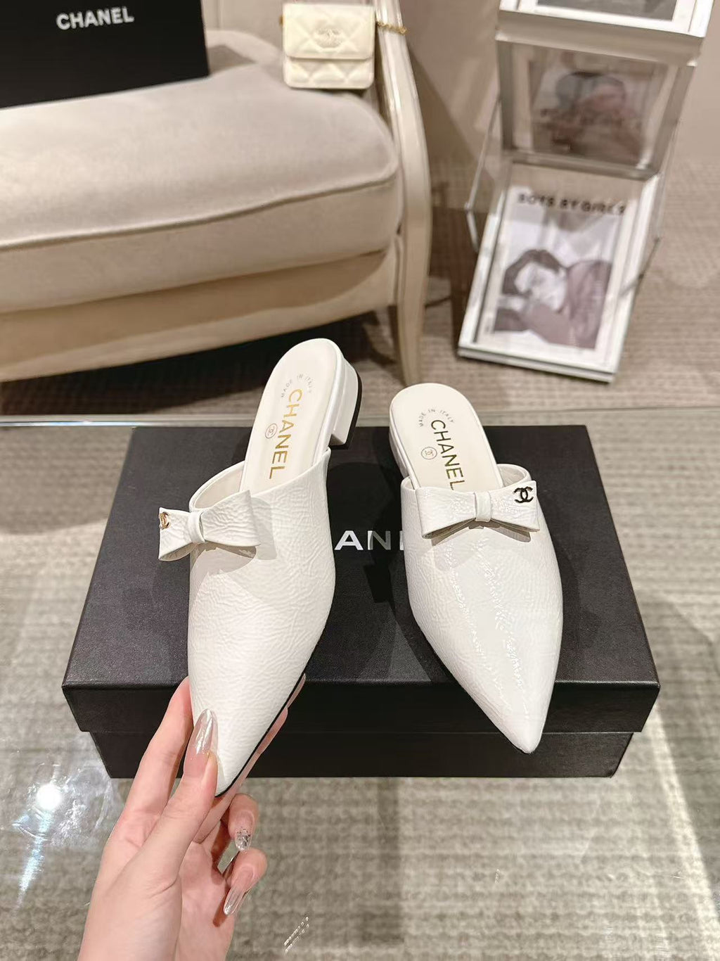White Chanel flats with bow strap, front view showing logo insole