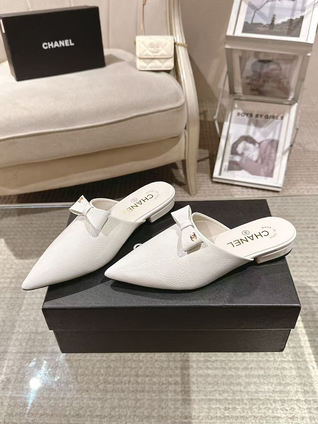 Pair of white Chanel pointed-toe flats with bow strap on display box