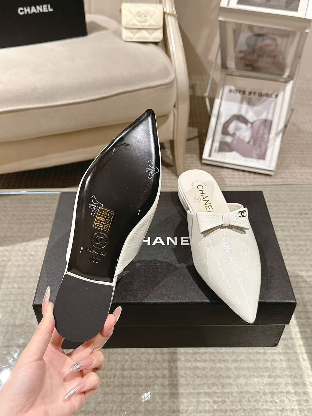 White Chanel flats on box, one showing logo on insole