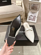 White Chanel flats on box, one showing logo on insole