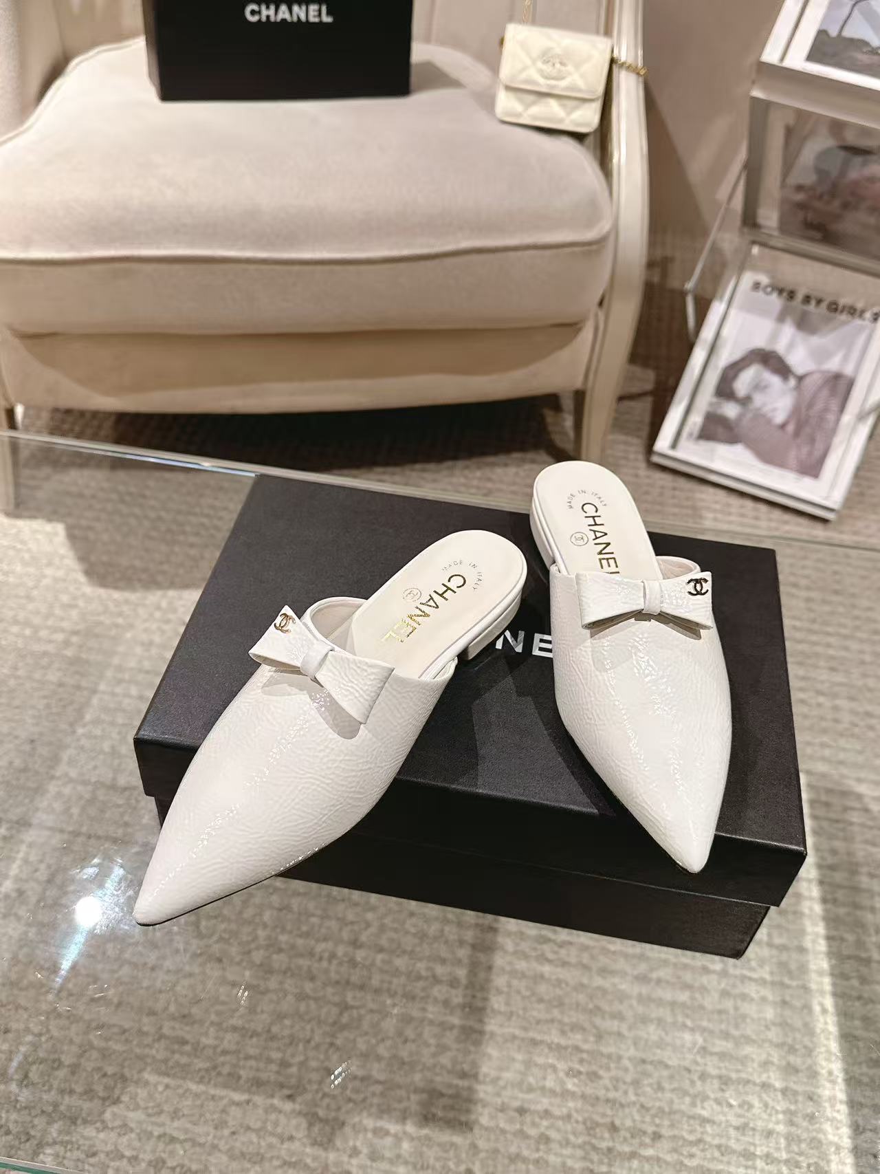 White Chanel pointed-toe flats with bow strap, shoes side-by-side