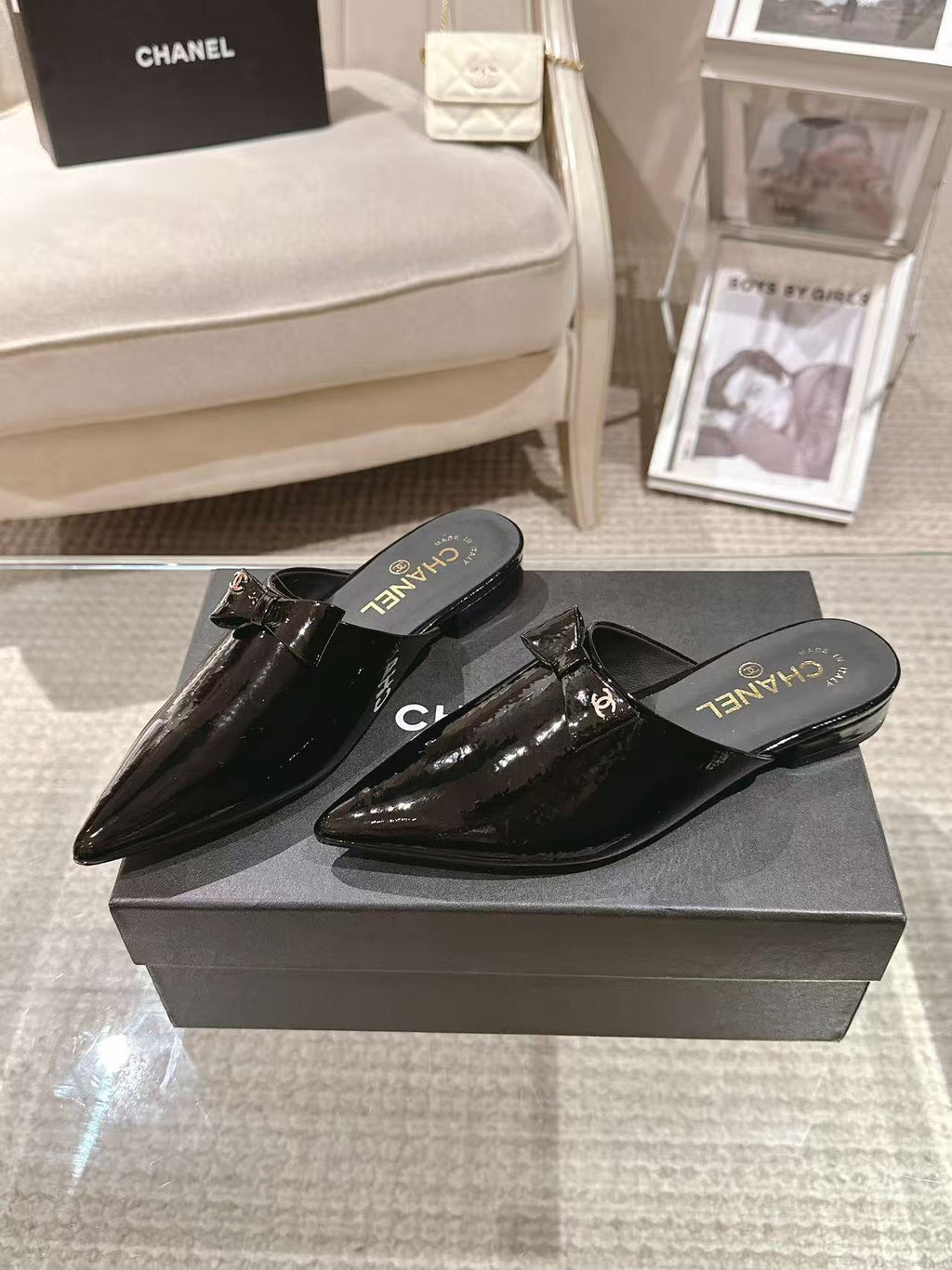 Women’s glossy black patent mules with pointed toe and CHANEL logo on footbed