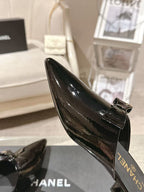 Women’s glossy black patent mule angled view with CHANEL logo on insole