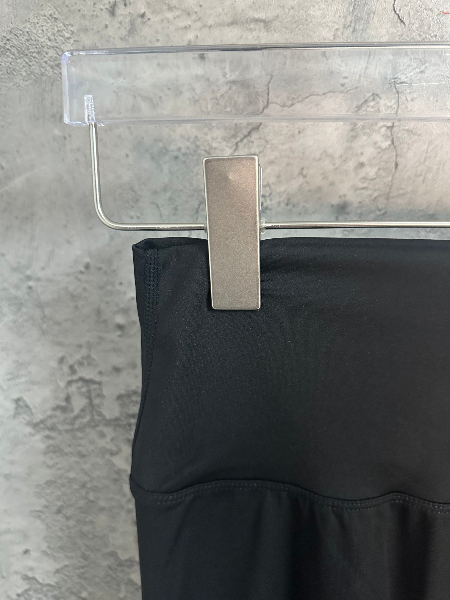 Black pants with yoke seam at waistband and straight leg opening.