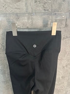 Black pants with small logo on front and V-shaped waistband seam.