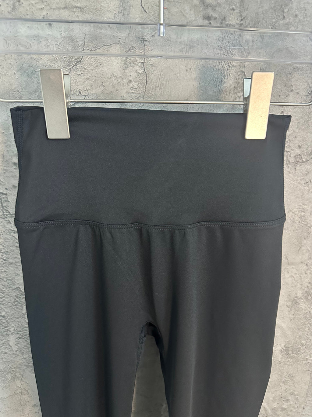 Black cropped pants with wide waistband and inner fly seam visible.