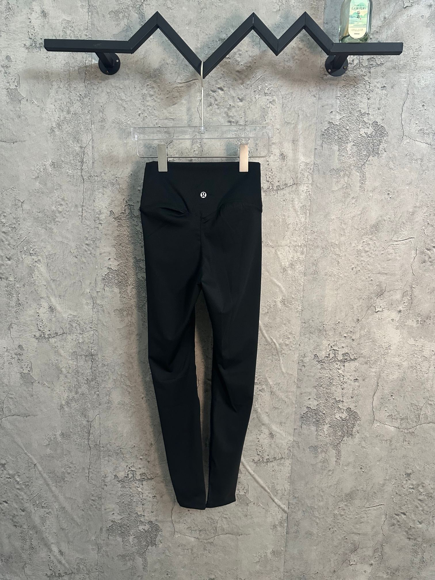 Black pants with front button closure and stitched seams.