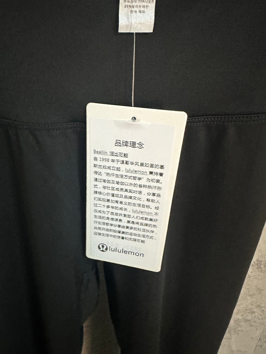 Black pants with white care tag hanging from the waistband.