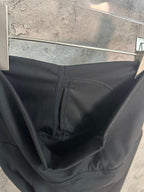 Black pants close-up showing waistband seam and interior pocket stitching.