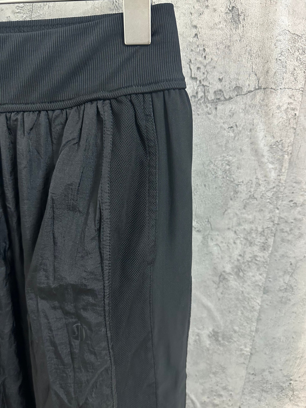 Dark pants with ribbed waistband and gathered panel detail