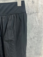 Dark pants with ribbed waistband and gathered panel detail