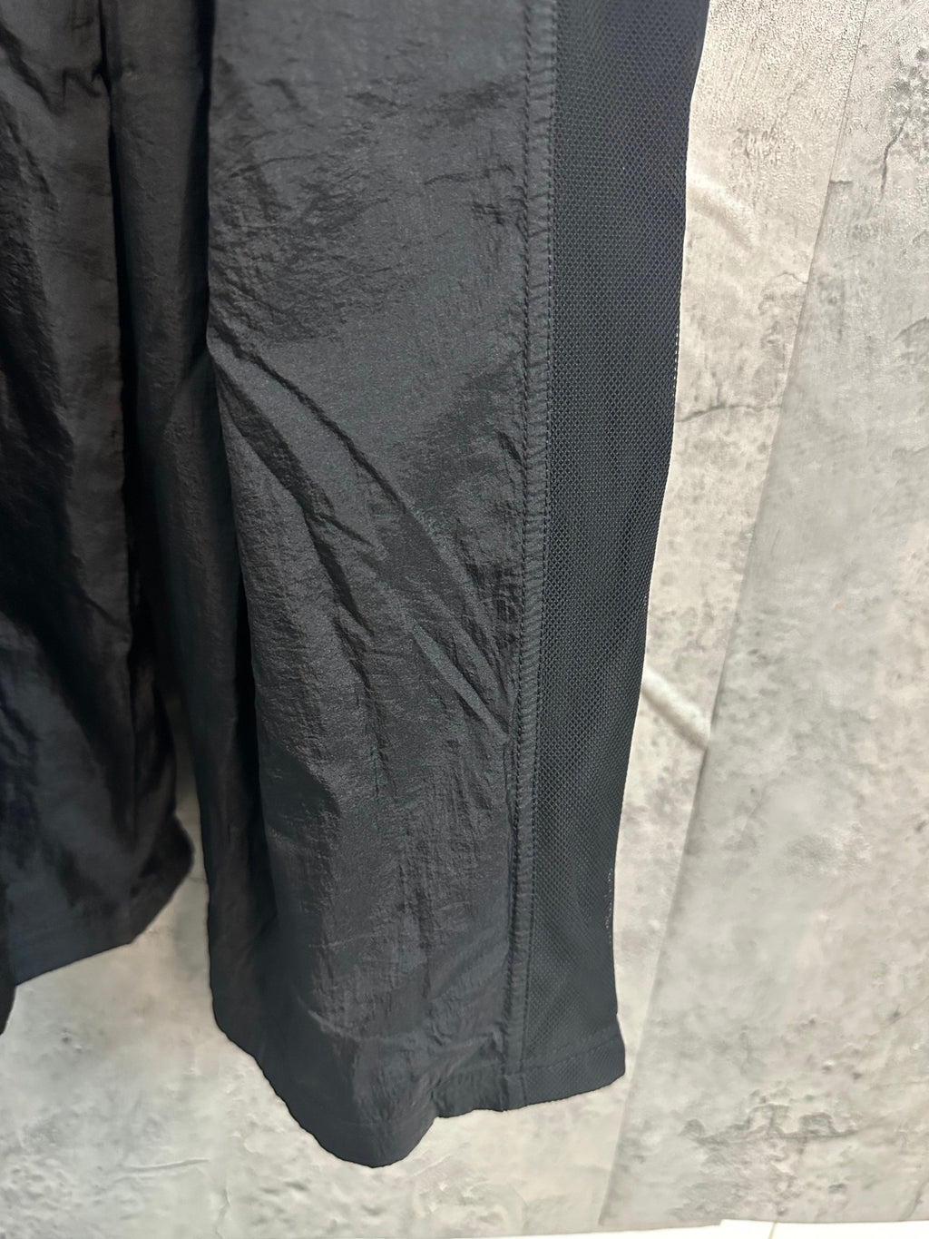 Dark wide-leg pants with stitched seams and gathered hem