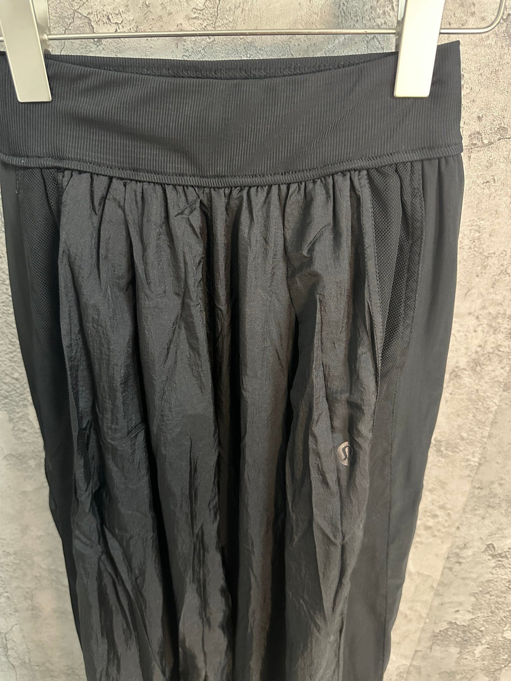 Dark pants waistband with elastic rib and gathered pleated panel