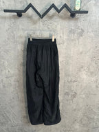 Dark wide-leg pants on hanger, elastic waistband and front pleats