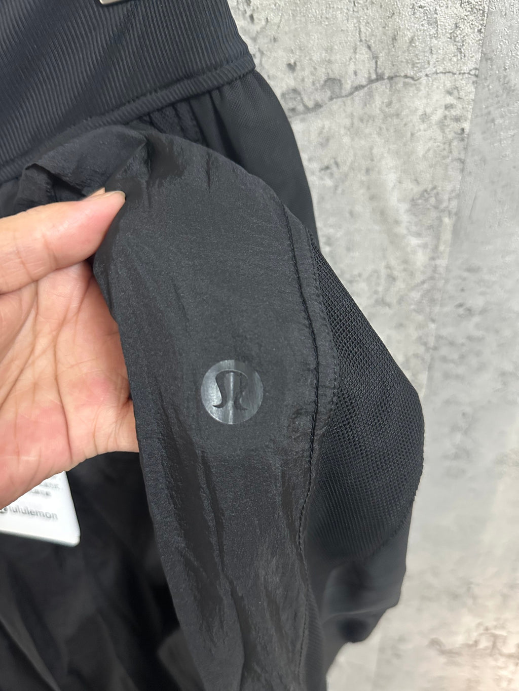 Dark pants with snap button closure and small circular logo patch