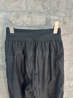 Dark wide-leg pants with ribbed waistband and gathered front fullness