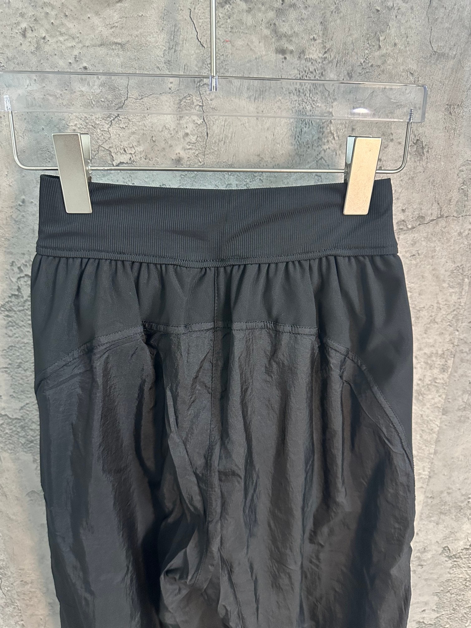 Dark wide-leg pants with ribbed waistband and gathered front fullness