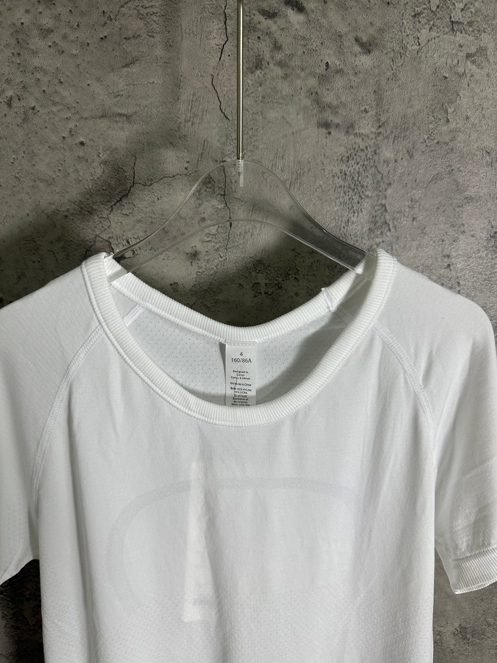 White crew-neck T-shirt close-up of neckline seam and size label