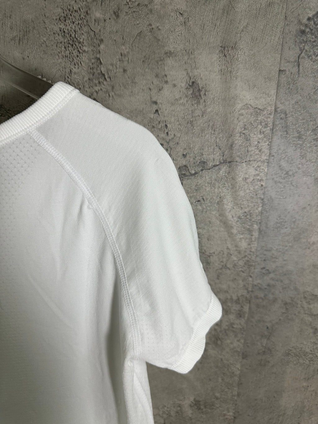 White T-shirt side view with stitched raglan seam and short sleeve hem