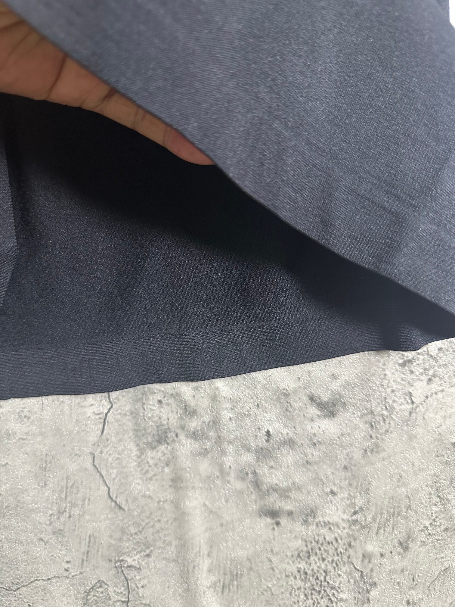 Dark heather T-shirt fabric close-up showing smooth knit texture