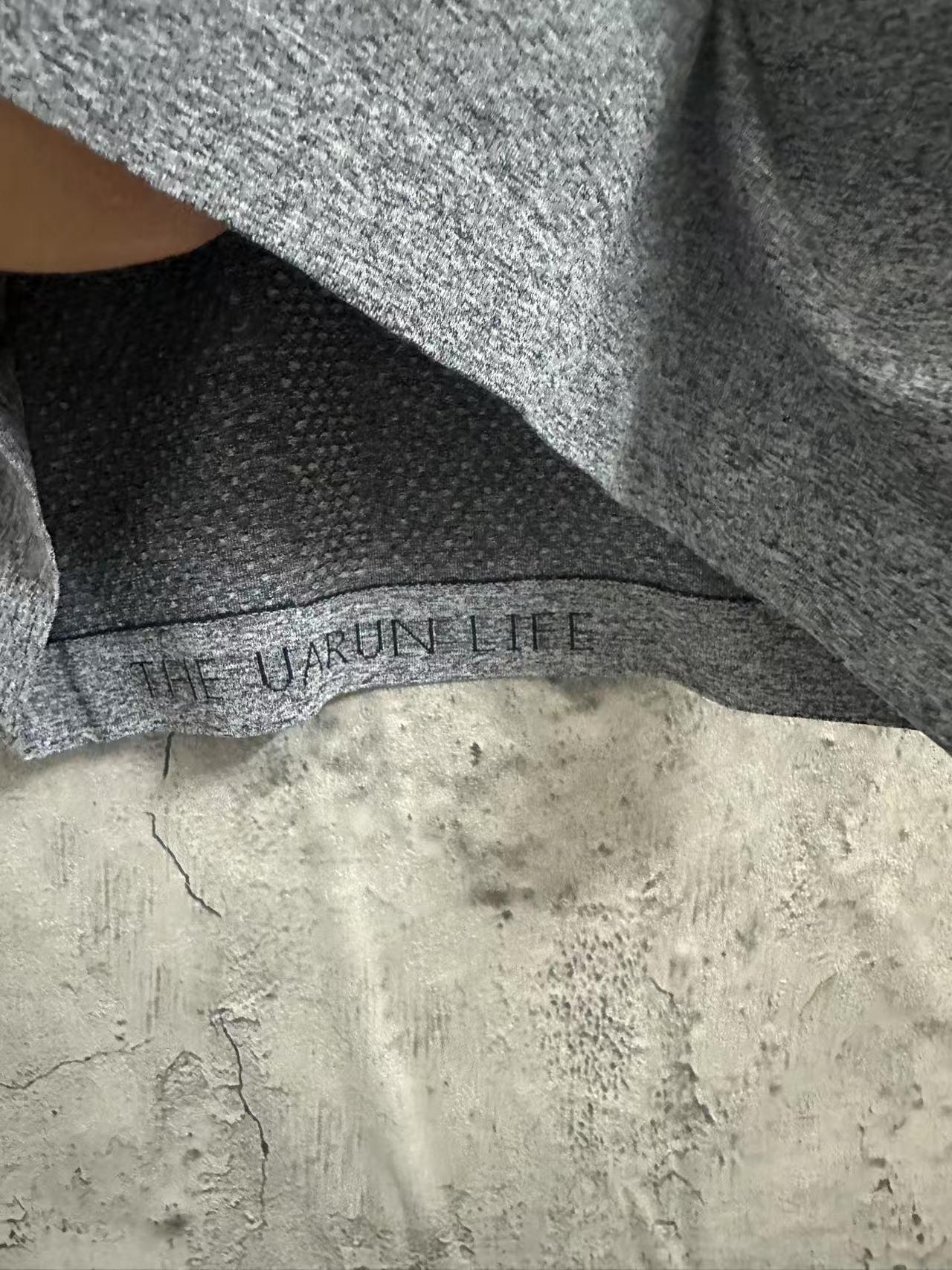 Kids gray heather T-shirt hem with “THE URBAN TREE” printed label