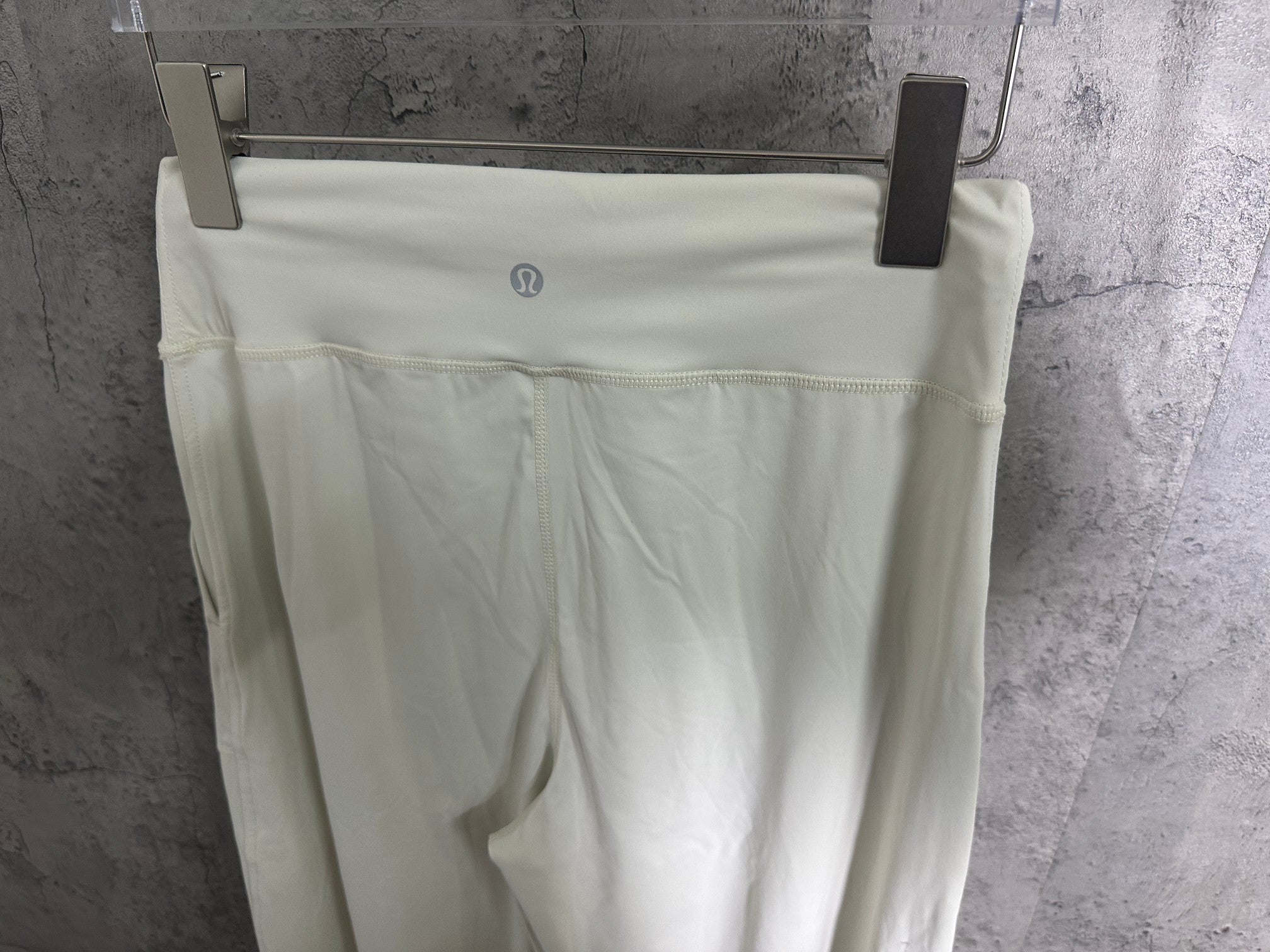 White pants back view with elastic waistband and small logo at center