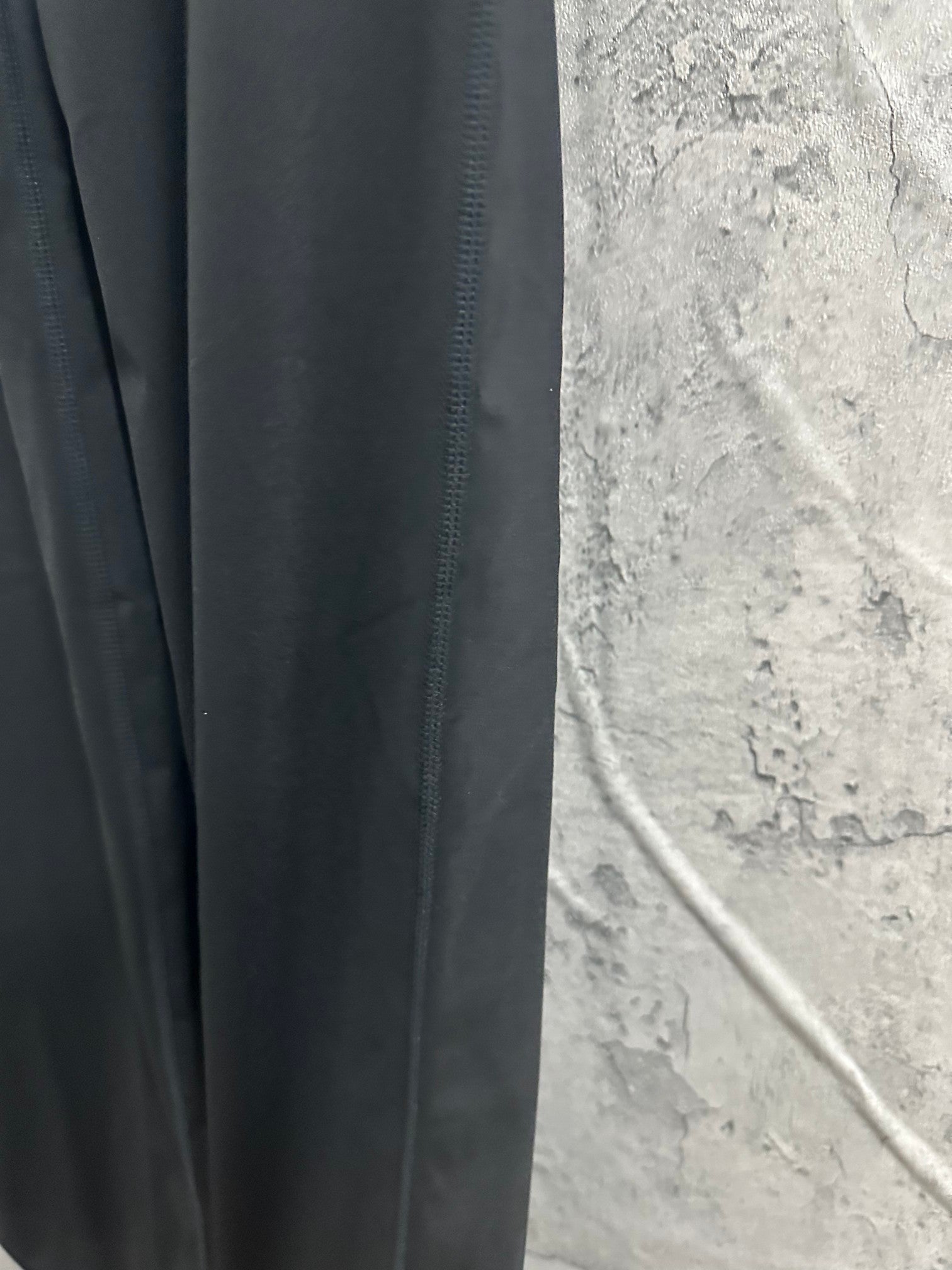 Dark pants with visible stitching on leg seam and side panel