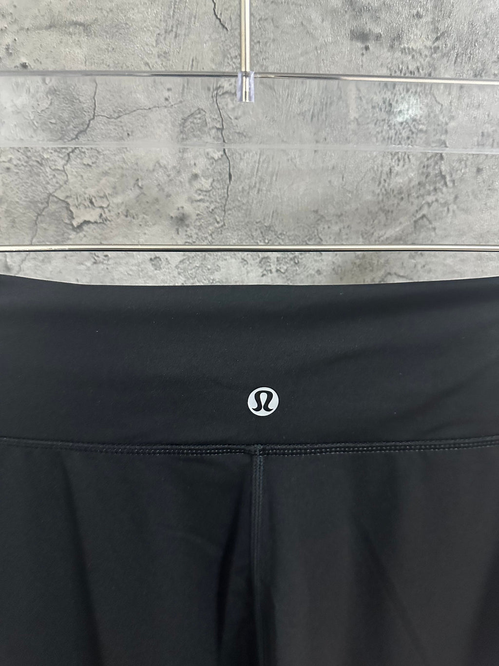 Black waistband with small circular logo and drawstring closure