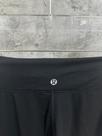 Black waistband with small circular logo and drawstring closure