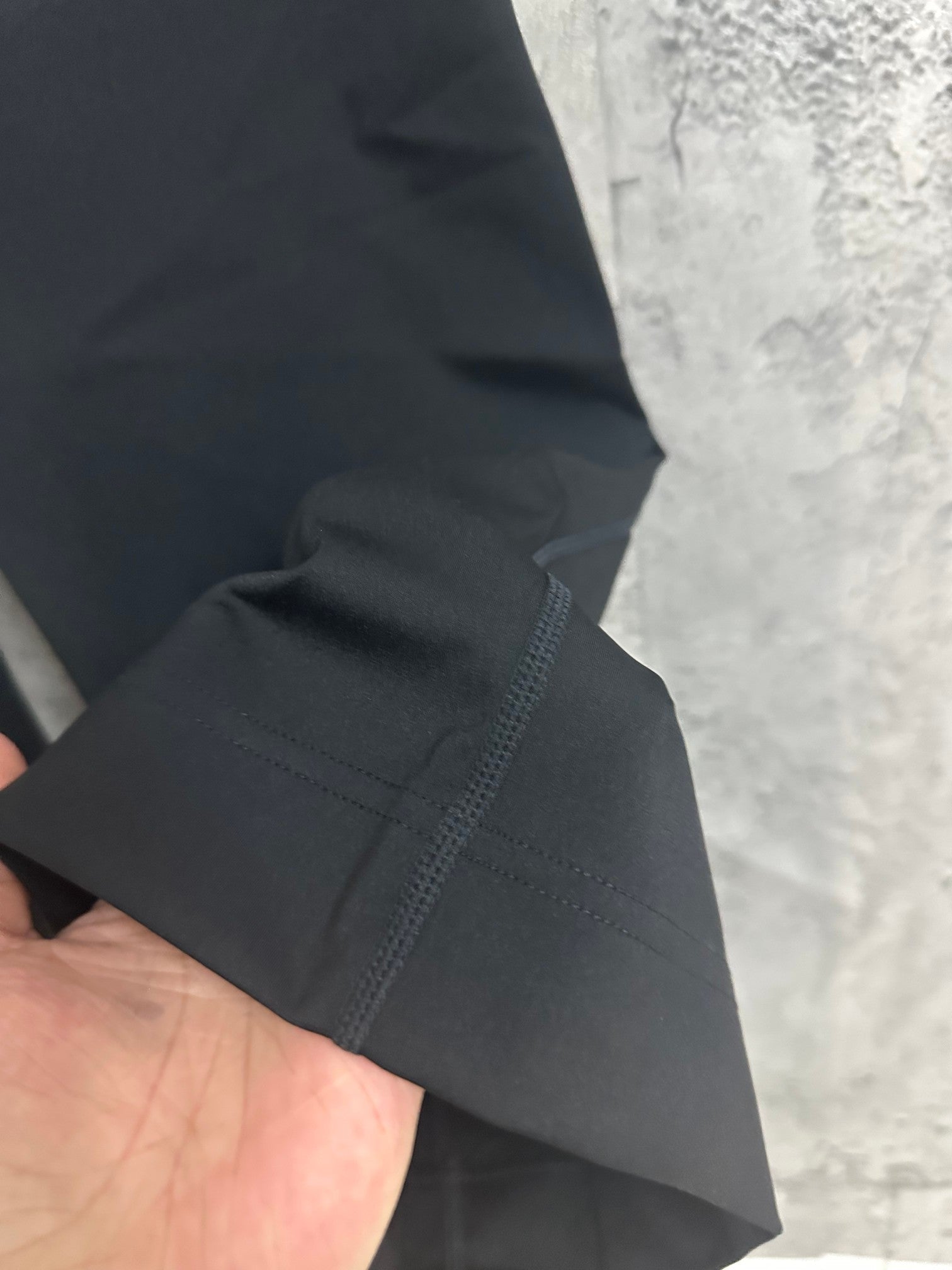 Dark pants hem area with stitched cuff and side panel seam