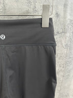 Dark gray pants side seam close-up with small logo on waistband