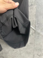 Dark gray drawstring pocket area with curved seam and stitching