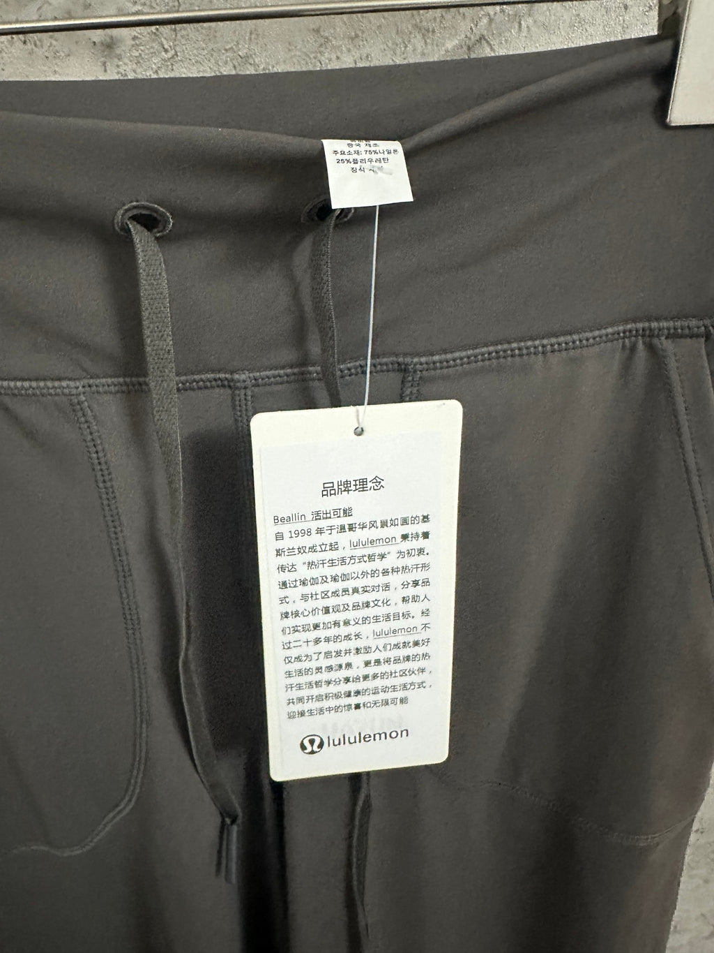 Dark gray drawstring pants with internal care tag on waistband