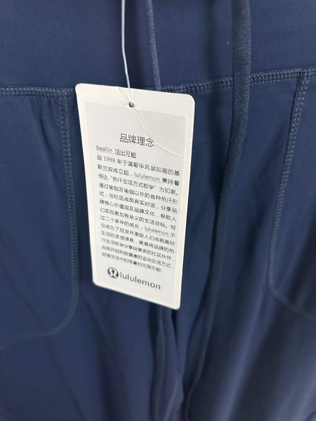 Navy pants with attached white product care tag