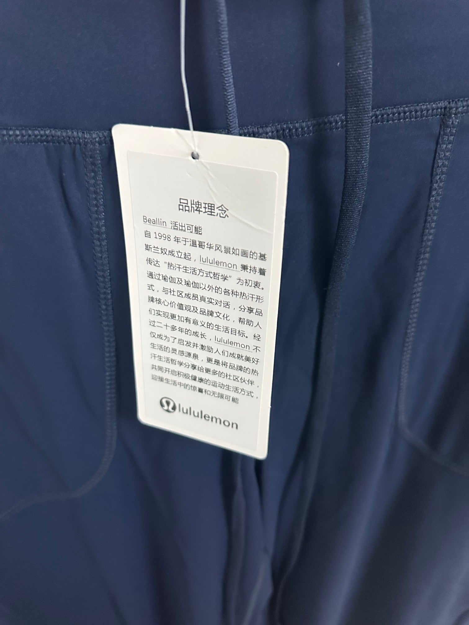 Navy pants with attached white product care tag