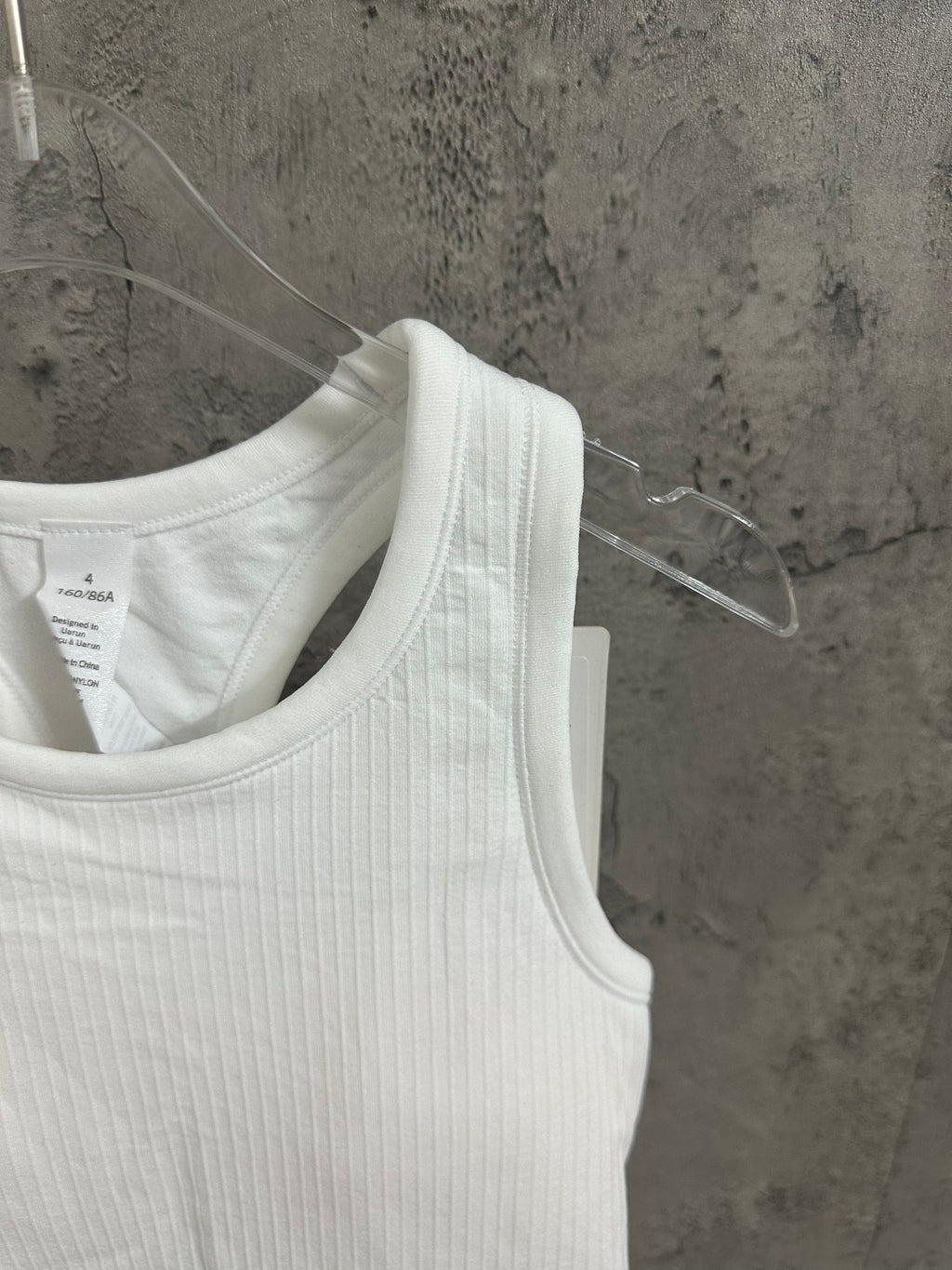 White sleeveless tank top close-up of ribbed knit scoop neckline