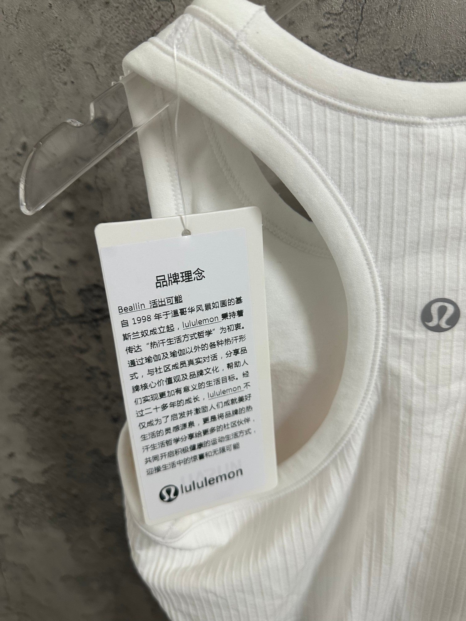 White ribbed tank top with lululemon hang tag and chest logo