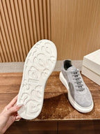 Grey suede low-top sneakers showing textured white outsole and lace-up upper