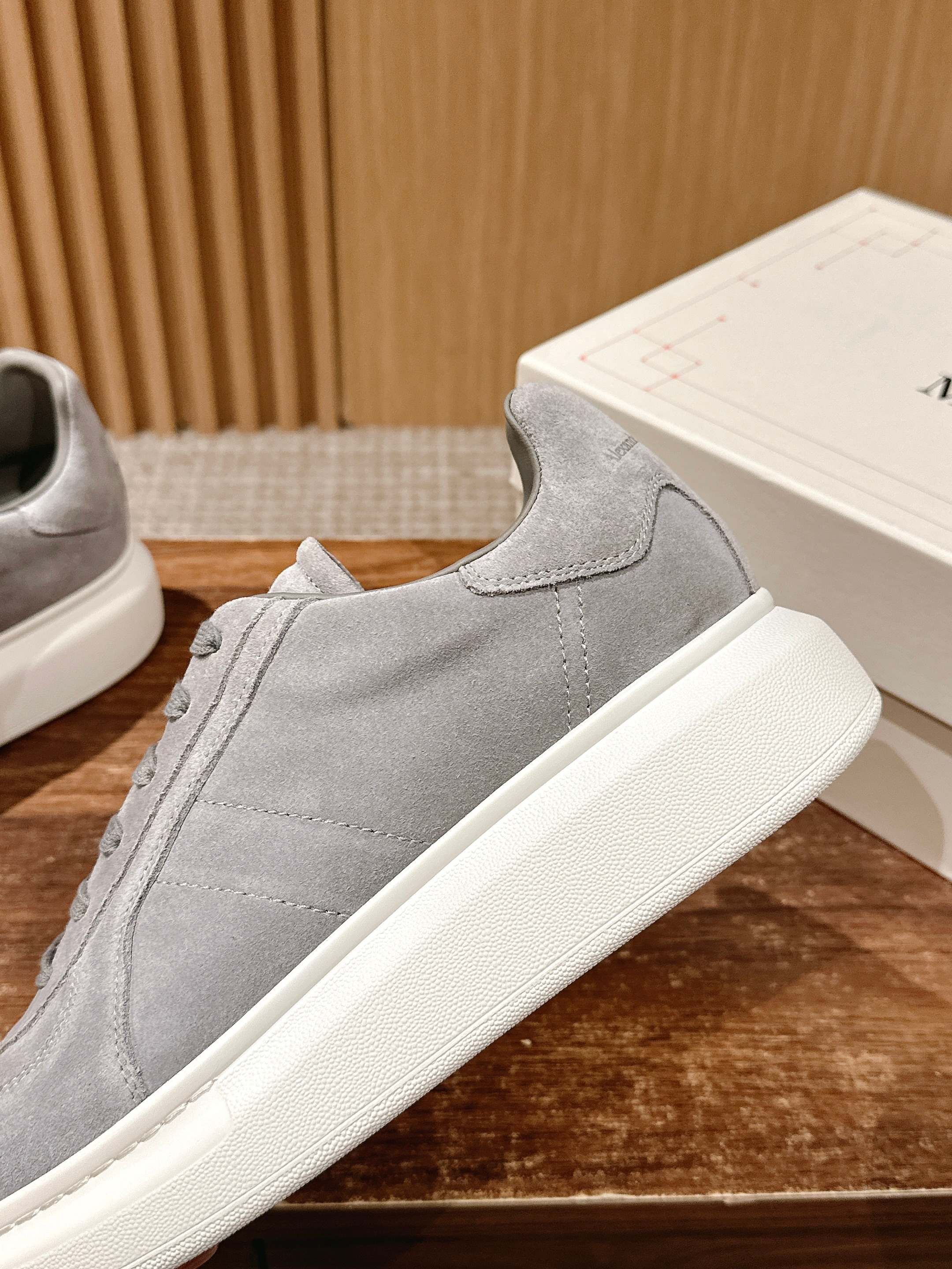 Grey suede low-top sneaker side view with lace-up closure and white sole
