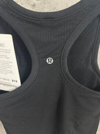 Black ribbed tank top with small circular logo on chest