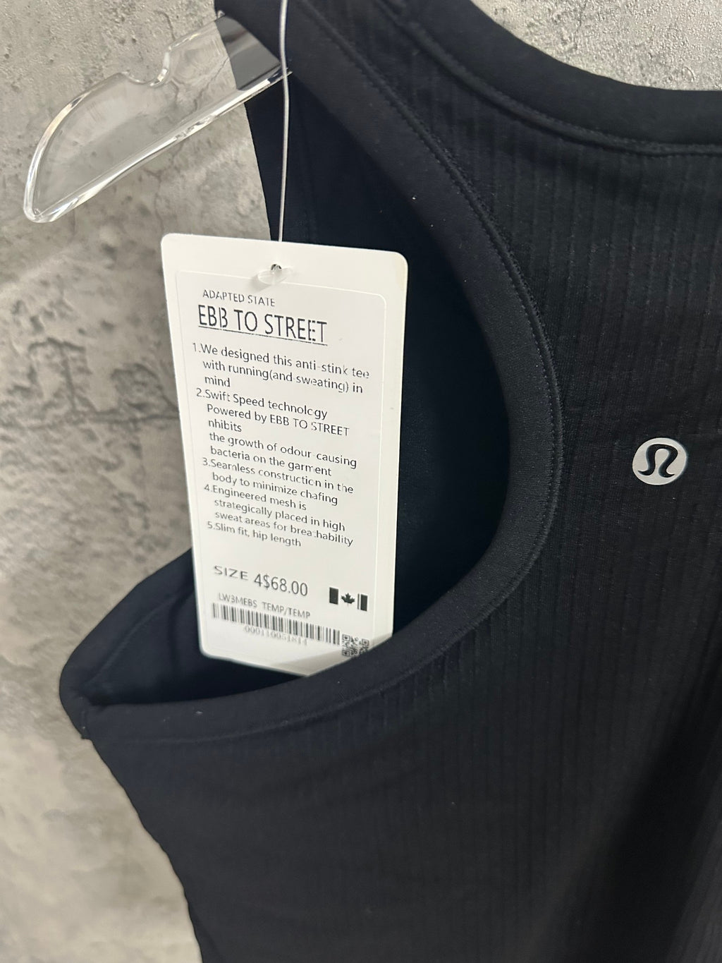Black sleeveless tank top on hanger with product and size labels